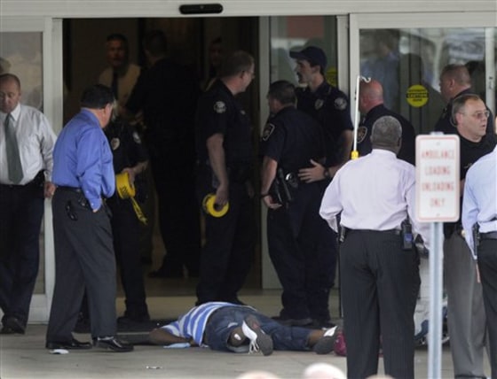 A body lies on the ground after a shooting at the patient discharge exit of Parkwest Medical Center Monday in Knoxville, Tenn. 